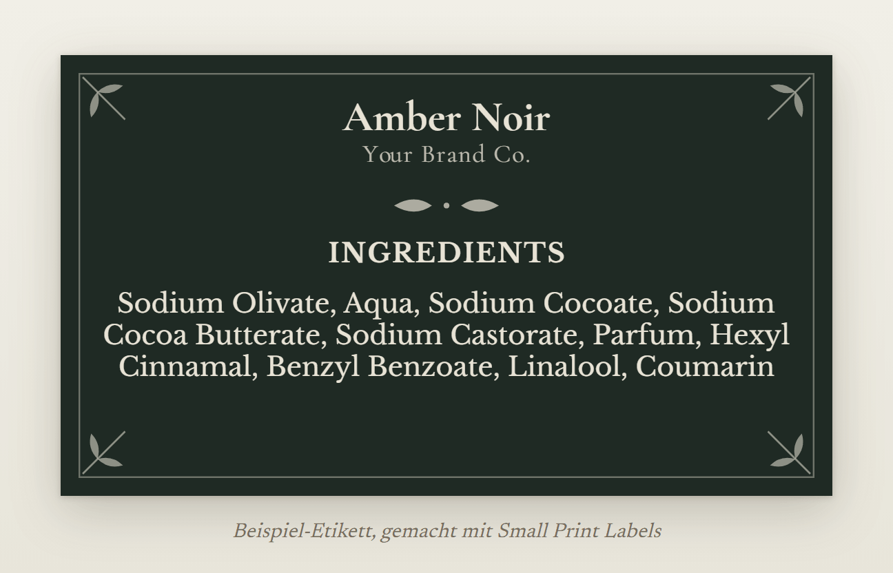Beispiel-Etikett für eine Seife, cremefarbene Schrift auf tiefem Grün mit botanischen Ecken: Amber Noir und ihre Liste der Bestandteile mit vier Duftstoff-Allergenen, 70 × 40 mm