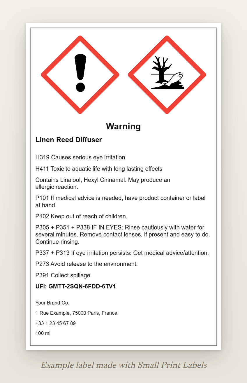 Example reed diffuser bottle label with the GHS07 and GHS09 pictograms and the signal word Warning: Linen Reed Diffuser, H319 and H411, the EUH208 line, six precautionary statements, a UFI and the supplier details, 60 × 100 mm